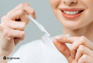 Figure using teeth whitening treatment