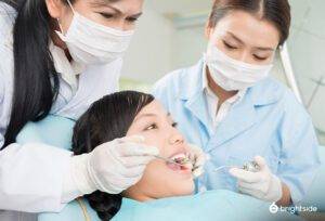 Patient getting dental checkup with two dentist